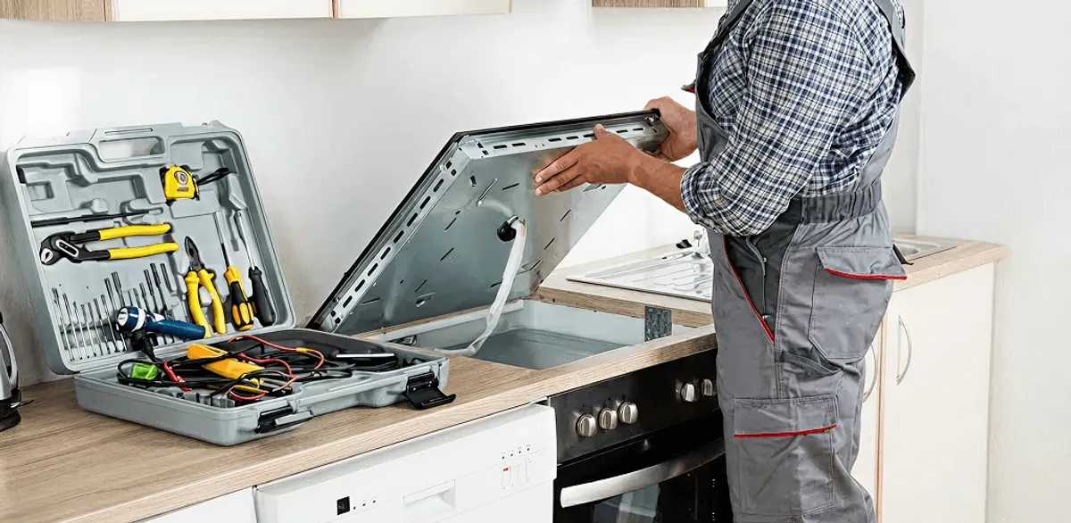 Handyman repairing a cooktop and checking wiring connections in Bellevue, WA