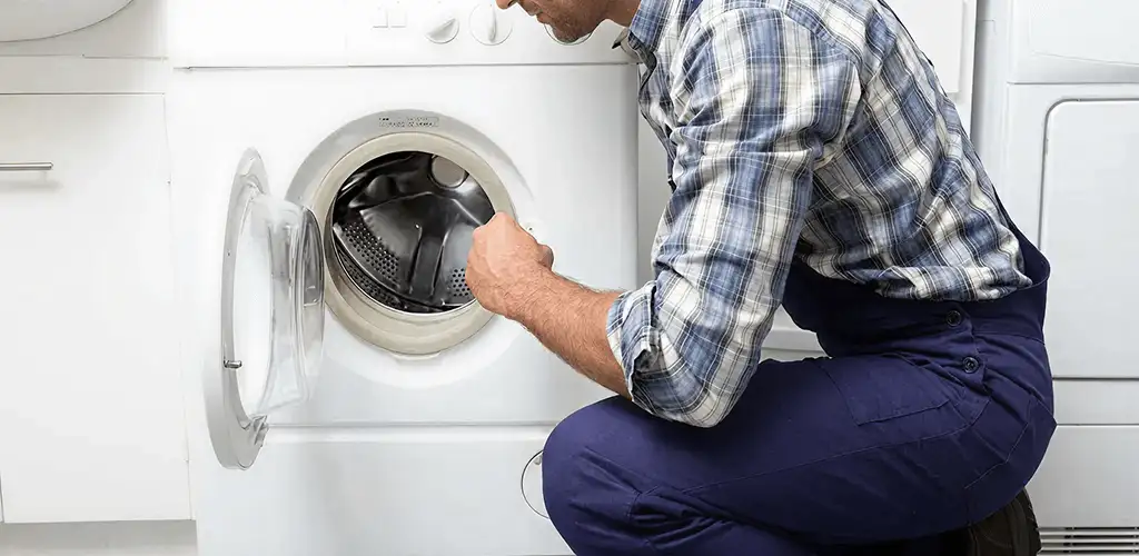 Handyman inspecting a dryer drum and internal parts for repair in Bellevue, WA