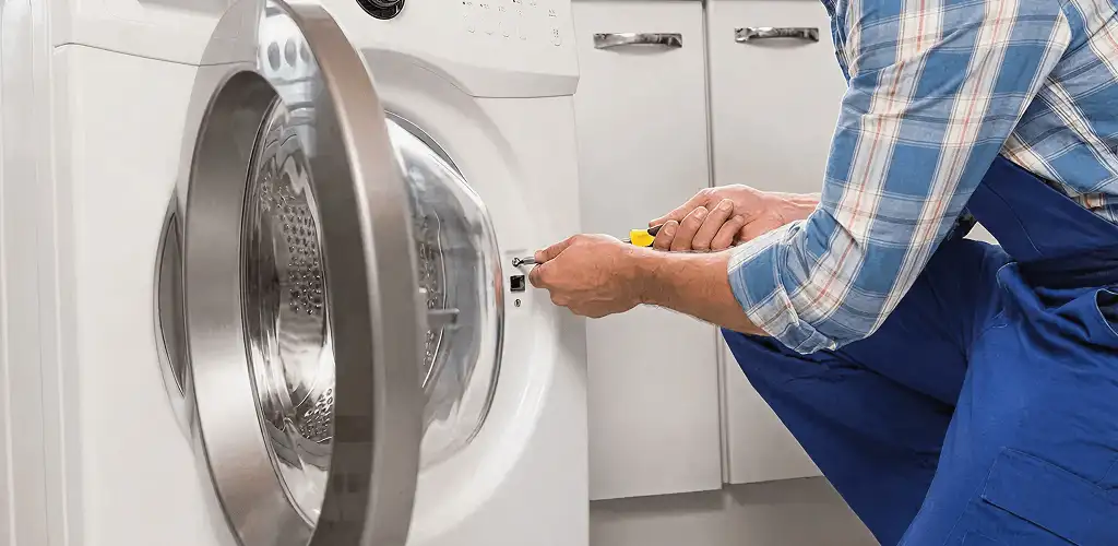 Handyman repairing a clothes dryer and checking electrical connections in Bellevue, WA