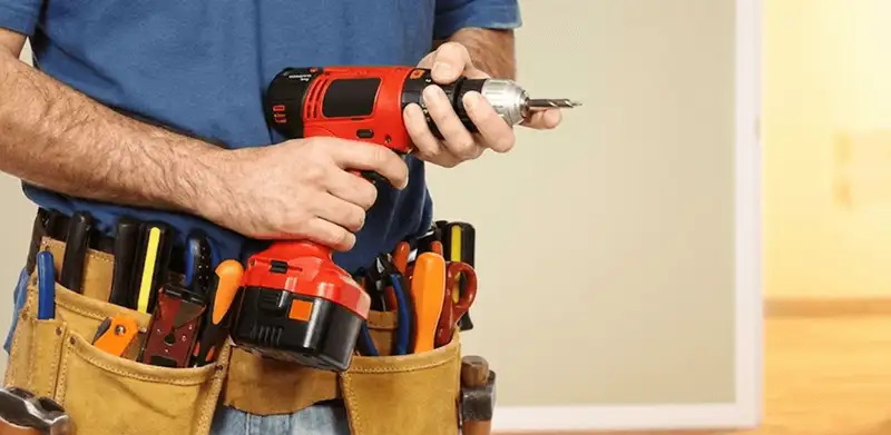 Handyman holding a power drill for home repairs and installations in Bellevue, WA