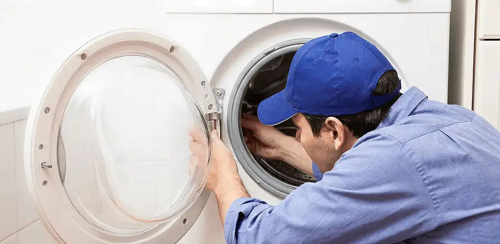 Washing machine repair handyman inspecting a front-load washer drum in Bellevue, WA