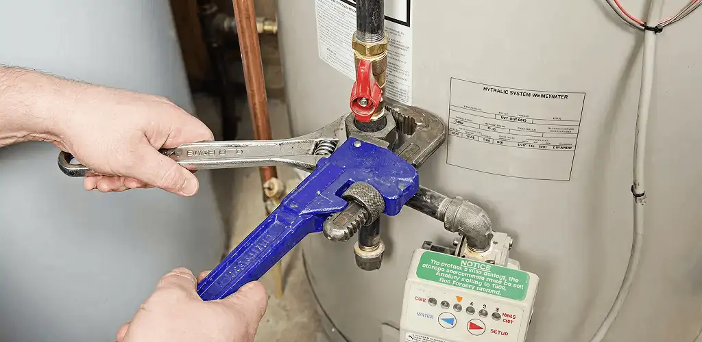 Water heater repair technician tightening the shutoff valve and supply line in Bellevue, WA